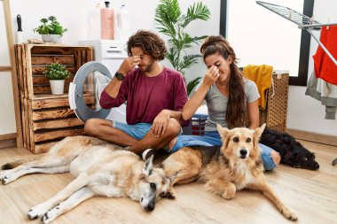 Genç İspanyol çift köpeklerle çamaşır yıkıyor. Burunlarını ve gözlerini ovuşturup yorgunluk ve baş ağrısı çekiyorlar. Stres ve hüsran kavramı. 