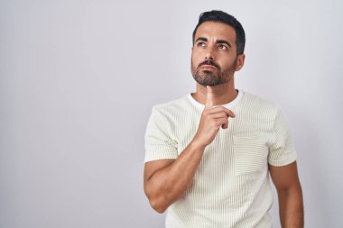 Sakallı İspanyol bir adam soyutlanmış arka planda durup parmak çenesinde şüpheye yoğunlaşmış ve kafasını kaldırıp merak ediyordu. 