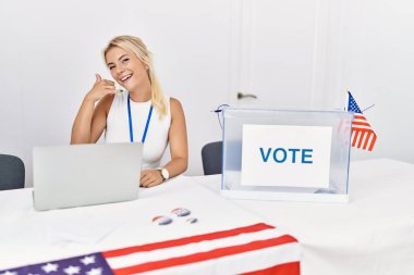 Amerika siyasi seçim kampanyasında genç beyaz bir kadın telefonla el ve parmak hareketleriyle gülümsüyor telefonda konuşuyormuş gibi. iletişim kavramları. 