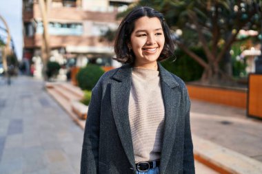 Young woman smiling confident looking to the side at park