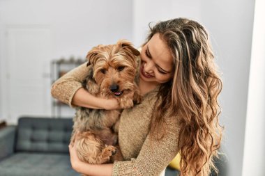Genç, güzel, İspanyol bir kadın. Köpeğine sarılıyor.