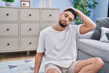 Genç Arap adam evde geriniyor.