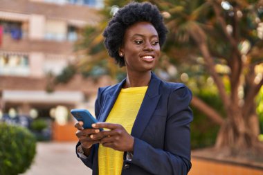 Young african american woman business executive using smartphone at park
