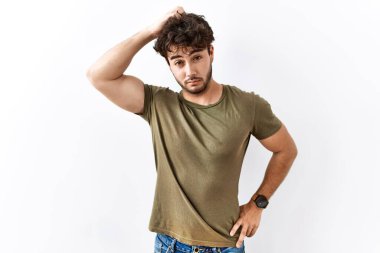 İzole edilmiş beyaz arka planda duran İspanyol bir adamın kafası karışmış ve soru sormayı merak ediyor. Şüpheyle kararsız, kafa kafaya düşünerek. Düşünceli kavram. 