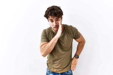 Hispanik bir adam tek başına beyaz arka planda duruyor. Ağzı açık, gizli dedikodular anlatıyor, kötü niyetli konuşmalar fısıldıyor. 