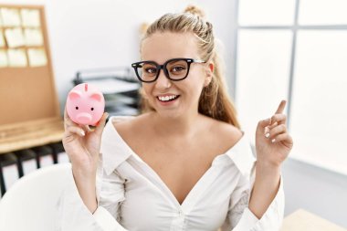 Kumbarayı tutan beyaz kadın gülümsüyor mutlu bir şekilde elini ve parmağını yana doğru uzatıyordu. 