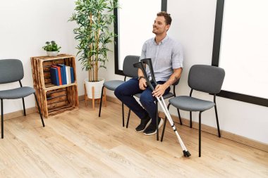 Klinikteki bekleme odasında kendine güvenen İspanyol bir adam oturuyor.