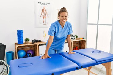 Rehabilitasyon kliniğinde kendine güvenen genç, İspanyol bir fizyoterapist.