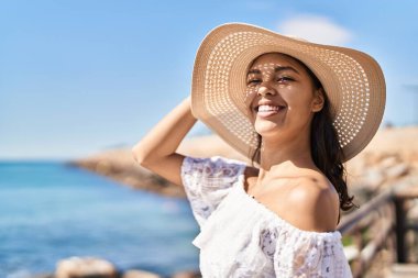 Genç Afrikalı Amerikalı turist. Deniz kenarında kendine güvenen yaz şapkası takıyor.