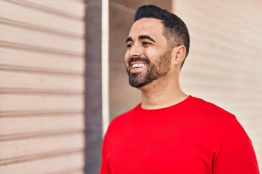 Sokakta kendinden emin gülümseyen İspanyol genç adam.