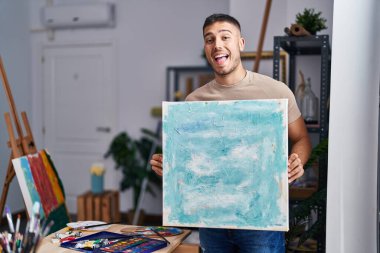 Genç İspanyol ressam tuvali tutuyor ve kahkahalarla gülüyor.. 