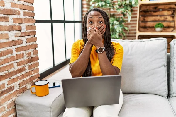 Mulher Africana Sentada Sofá Usando Laptop Casa Chocado Cobrindo Boca — Fotografia de Stock