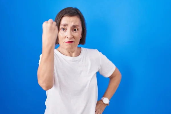 Hispanische Frau Mittleren Alters Steht Vor Blauem Hintergrund Und Macht — Stockfoto