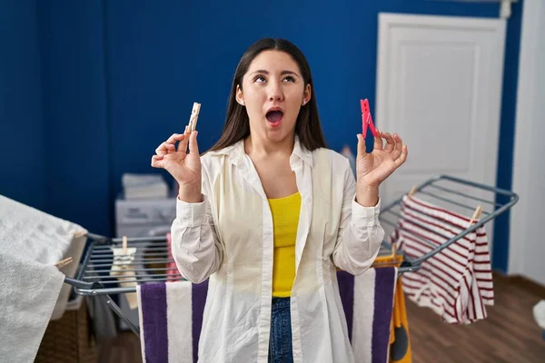 Young Latin Woman Holding Clothespins Hanging Clothes Clothesline Angry Mad — Stockfoto