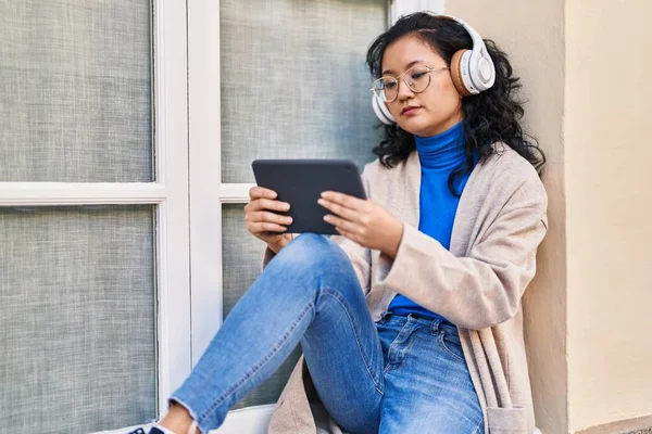 Young Chinese Woman Using Touchpad Headphones Street — Φωτογραφία Αρχείου