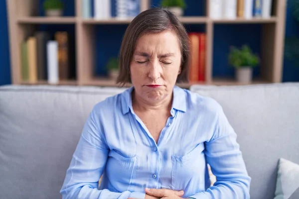 Mujer Hispana Mediana Edad Sentada Sofá Casa Con Mano Estómago — Foto de Stock