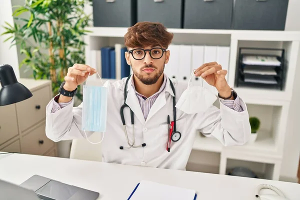 Arab Man Beard Wearing Doctor Uniform Holding Medical Mask Relaxed — Stockfoto