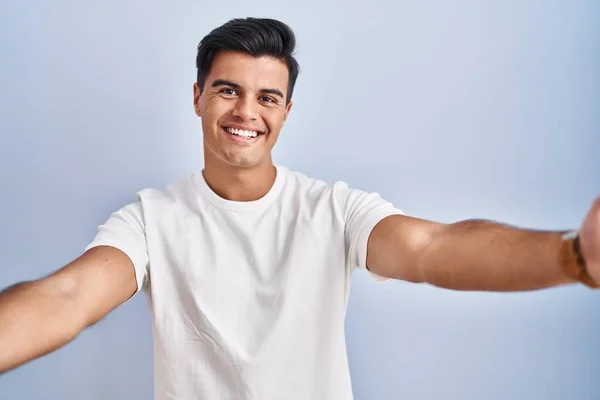 Homem Hispânico Sobre Fundo Azul Olhando Para Câmera Sorrindo Com — Fotografia de Stock