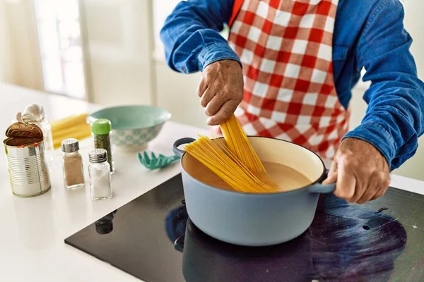 シニア男調理スパゲティでキッチン — ストック写真