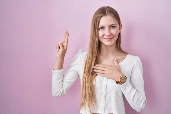 Pembe Arka Planda Duran Beyaz Bir Kadın Gülümsüyor Elleri Göğsünde — Stok fotoğraf