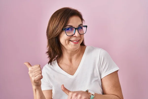 Middle Age Hispanic Woman Standing Pink Background Pointing Back Hand — Stockfoto