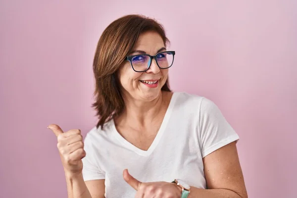 Hispanische Frau Mittleren Alters Steht Über Rosa Hintergrund Und Zeigt — Stockfoto