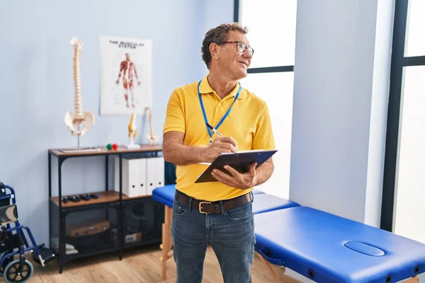 Middle Age Man Physiotherapist Writing Clipboard Laundry Room — Stock Photo, Image