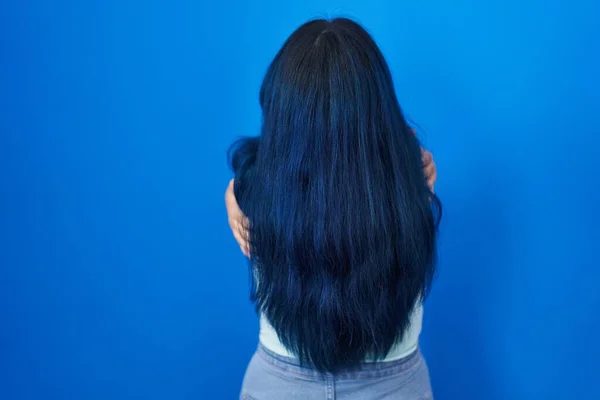 Молодая Современная Девушка Голубыми Волосами Стоящая Синем Фоне Обнимающая Себя — стоковое фото