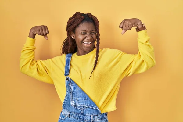 African Woman Standing Yellow Background Showing Arms Muscles Smiling Proud — Stockfoto