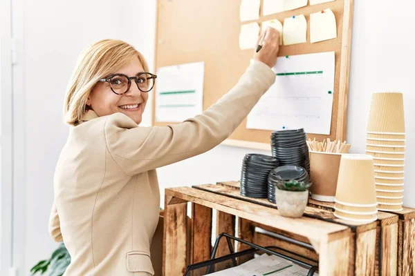 Middle Age Blonde Woman Smiling Confident Writing Corkboard Office — Stock Photo, Image