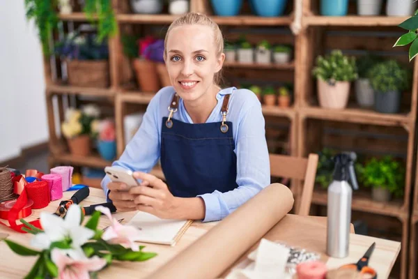 Joven Florista Rubia Sonriendo Confiada Usando Teléfono Inteligente Floristería —  Fotos de Stock