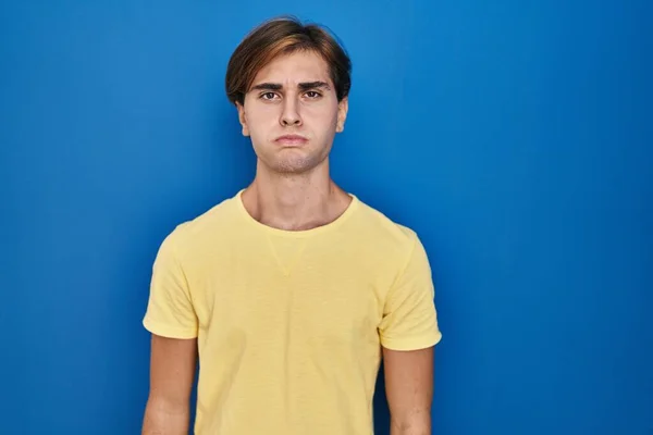 Young Man Standing Blue Background Puffing Cheeks Funny Face Mouth — Stockfoto