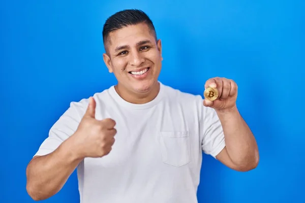 Jovem Hispânico Segurando Moeda Virtual Bitcoin Sorrindo Feliz Positivo Polegar — Fotografia de Stock