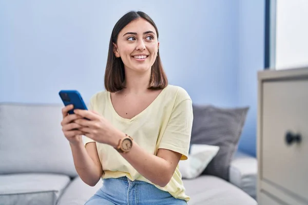 Jonge Spaanse Vrouw Met Behulp Van Smartphone Zitten Bank Thuis — Stockfoto