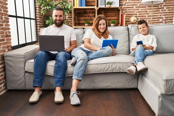 Family smiling confident using technology device at home