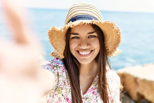 若いですラテン女の子身に着けています夏の帽子作り自画撮りカメラによってザビーチ — ストック写真