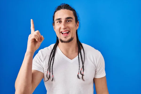 Hispanic Man Long Hair Standing Blue Background Pointing Finger Successful — Stockfoto