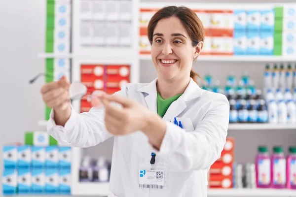 Joven Farmacéutica Sonriendo Confiada Sosteniendo Gafas Farmacia — Foto de Stock