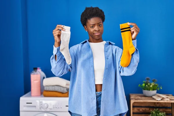 持有干净的安迪脏袜子的非裔美国女人怀疑和紧张 皱着眉头因问题而烦恼 消极的人 — 图库照片