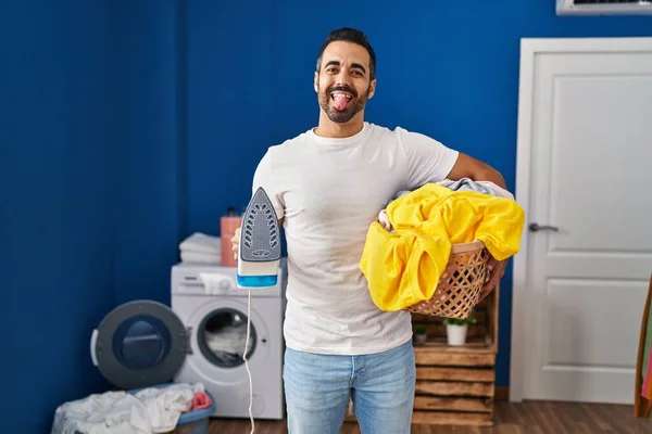 Jovem Hispânico Com Barba Segurando Ferro Roupas Casa Colando Língua — Fotografia de Stock