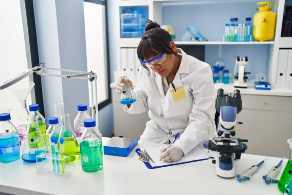 Young Beautiful Latin Woman Scientist Holding Test Tube Writing Report — Foto Stock