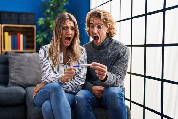 Young Couple Holding Pregnancy Test Result Angry Mad Screaming Frustrated — Stock fotografie