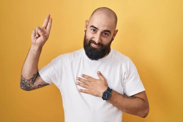Young Hispanic Man Beard Tattoos Standing Yellow Background Smiling Swearing —  Fotos de Stock