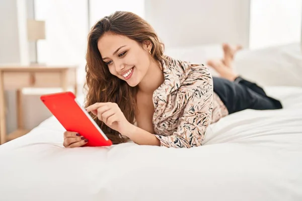Νεαρή Όμορφη Ισπανόφωνη Γυναίκα Που Χρησιμοποιεί Touchpad Ξαπλωμένη Στο Κρεβάτι — Φωτογραφία Αρχείου