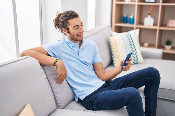 Young Hispanic Man Using Smartphone Sitting Sofa Home — Stock Photo, Image