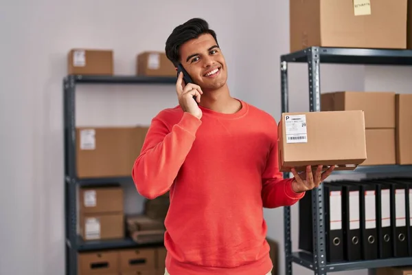 Young Hispanic Man Ecommerce Business Worker Talking Smartphone Holding Package — Stock Fotó