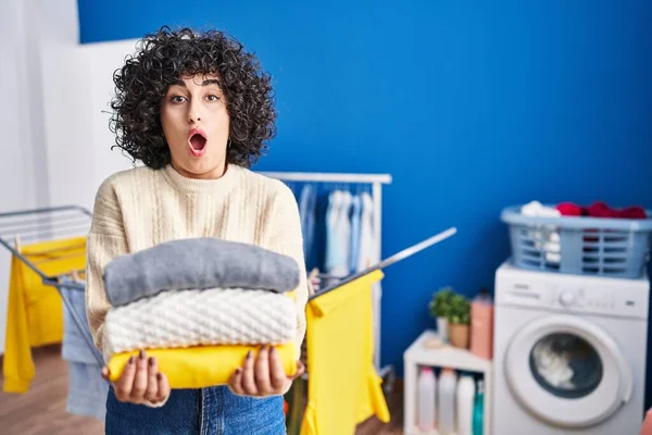 Young Brunette Woman Curly Hair Holding Clean Laundry Afraid Shocked — Stock Photo, Image