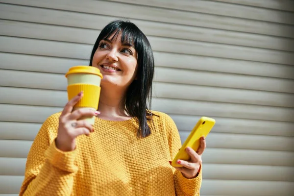 Joven Morena Sonriendo Feliz Usando Smartphone Bebiendo Una Taza Café — Foto de Stock