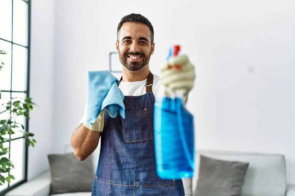 Joven Hombre Hispano Sonriendo Confiado Sosteniendo Pulverizador Casa — Foto de Stock