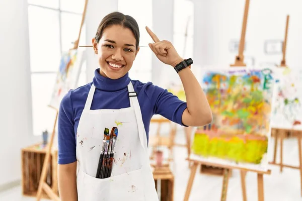 Mujer Morena Joven Estudio Arte Sonriendo Apuntando Cabeza Con Dedo —  Fotos de Stock